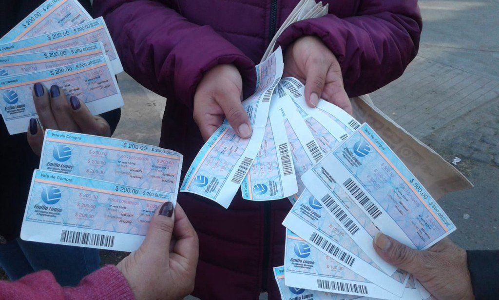 Personas intentan comprar en un supermercado con los tickets que les dieron punteros políticos