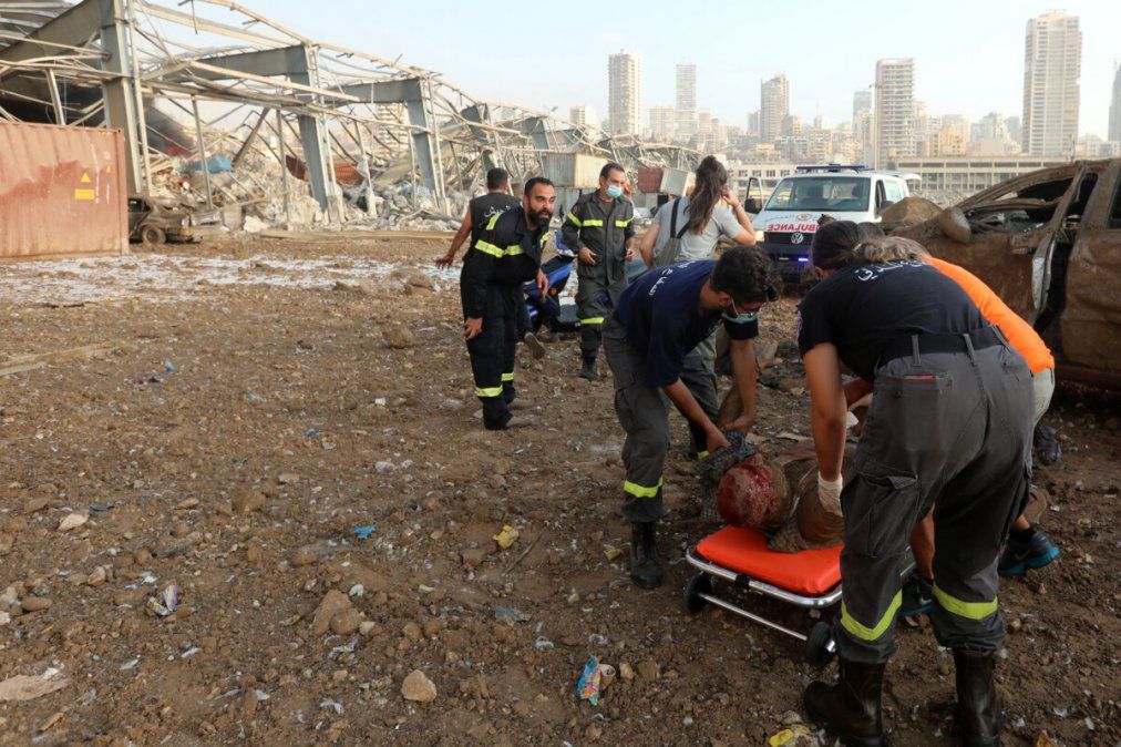 Un herido es colocado en una camilla por personal de emergencias tras las explosiones en el puerto de Beirut